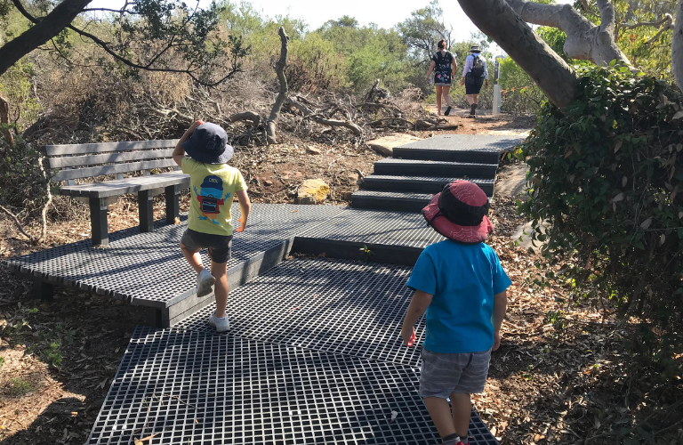 As you hit the first vantage point, be sure to take in the sights. Boys walking up stairs on the Malabar Headland circuit walk