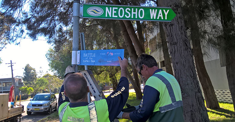 Council staff installing 75th commemorative street signs in Maroubra