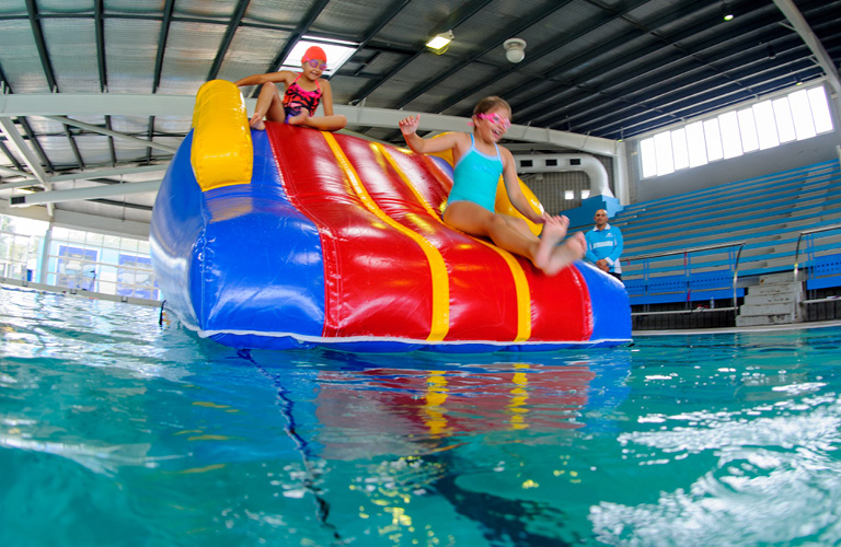 two girls sliding down inflatable 