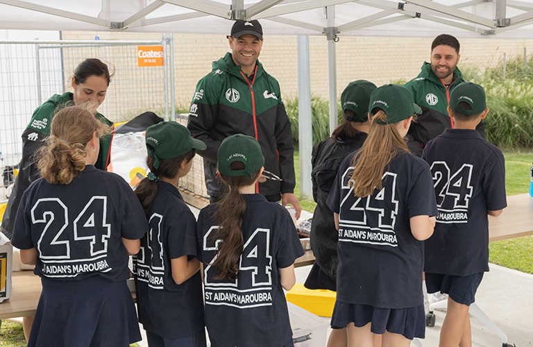 Young students line up for a barbecue lunch during a Junior League Clinic at Heffron Park in Maroubra.