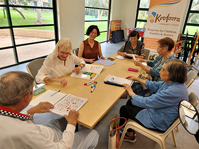 A photo of older people around a table talking 