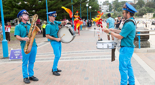 Glorious Sousaphonics - 3 musicians playing saxophone and drums at Coogee Beach