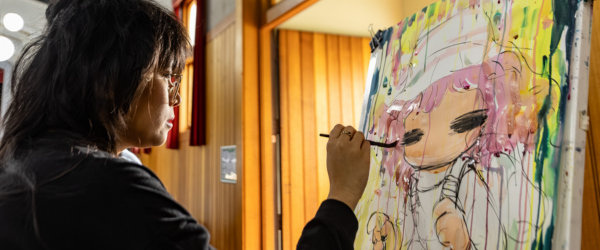 An artist paints a vibrant illustration within Randwick Town Hall.