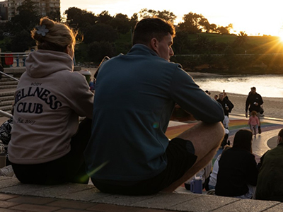 Two people at Coogee at sunrise, looking around the water