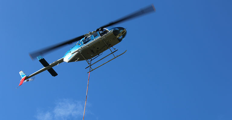 Helicopter lifting building supplies into Malabar Headland National Park